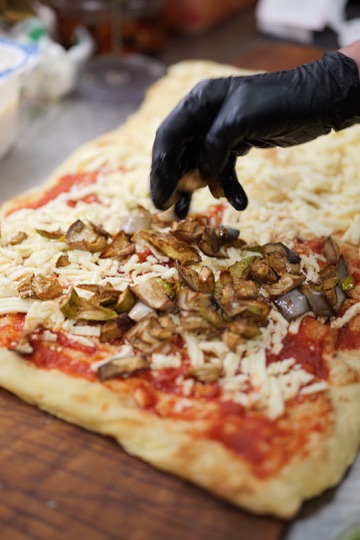 Ogni pizza preparata con cura, un ingrediente alla volta
